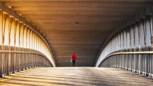 man walking away on bridge