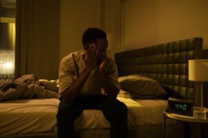 man sitting on bed in the dark